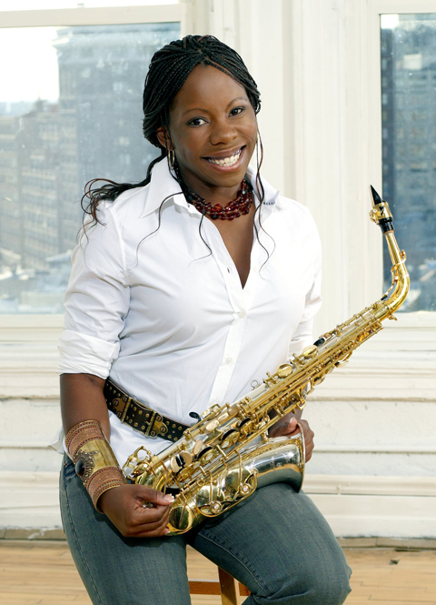Tia Fuller smiles and poses with her saxophone